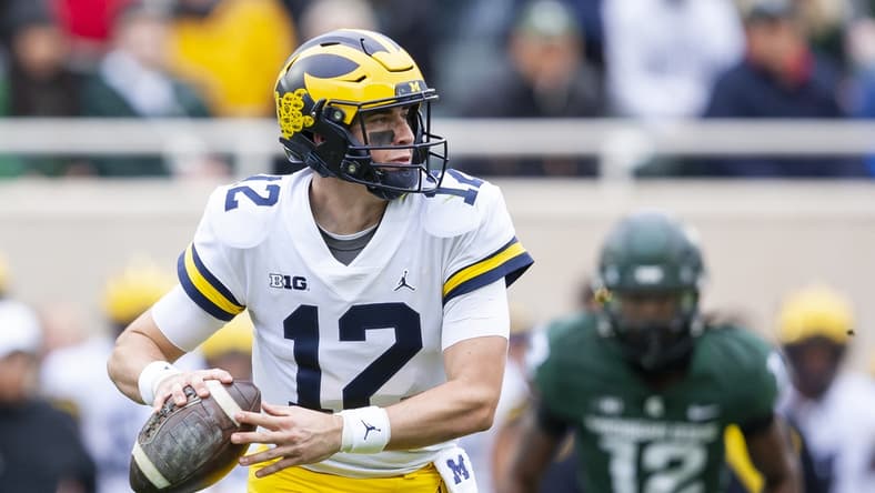 Oct 30, 2021; East Lansing, Michigan, USA; Michigan Wolverines quarterback Cade McNamara (12) looks to pass the ball during the first quarter against the Michigan State Spartans at Spartan Stadium. Mandatory Credit: Raj Mehta-USA TODAY Sports