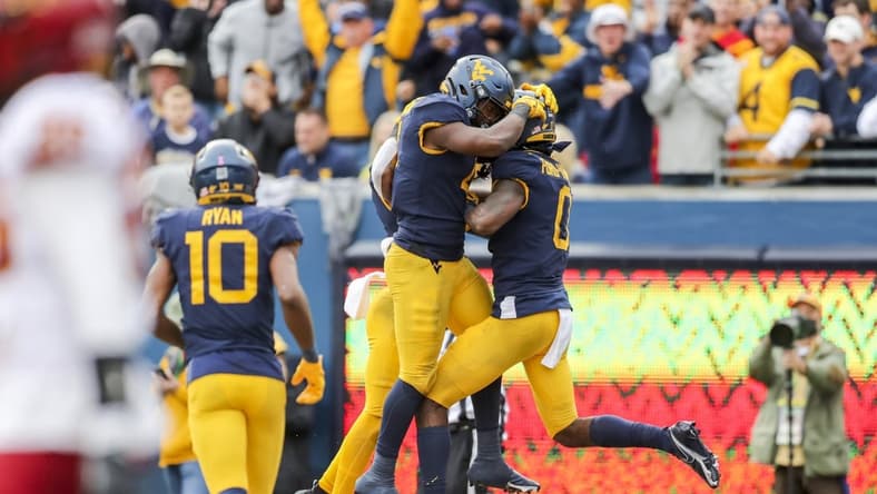 Oct 30, 2021; Morgantown, West Virginia, USA; West Virginia Mountaineers wide receiver Bryce Ford-Wheaton (0) celebrates with West Virginia Mountaineers running back Leddie Brown (4) after catching a pass for a touchdown during the third quarter against the Iowa State Cyclones at Mountaineer Field at Milan Puskar Stadium. Mandatory Credit: Ben Queen-USA TODAY Sports