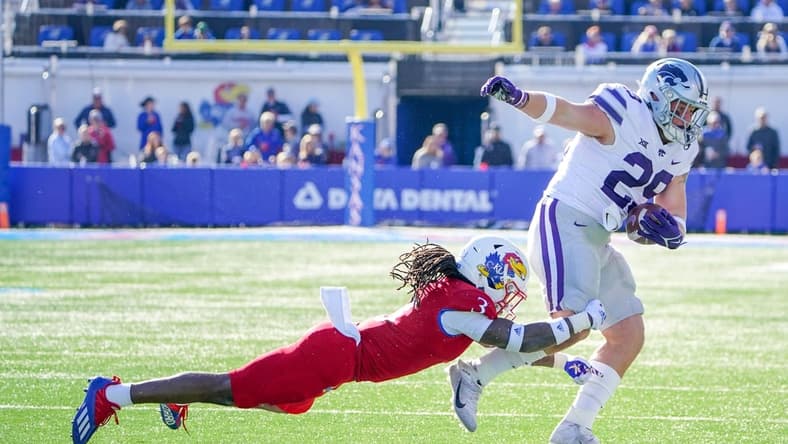 Nov 6, 2021; Lawrence, Kansas, USA; Kansas State Wildcats fullback Jax Dineen (29) runs the ball and is tackled by Kansas Jayhawks safety Ricky Thomas Jr. (3) during the first half at David Booth Kansas Memorial Stadium. Mandatory Credit: Denny Medley-USA TODAY Sports