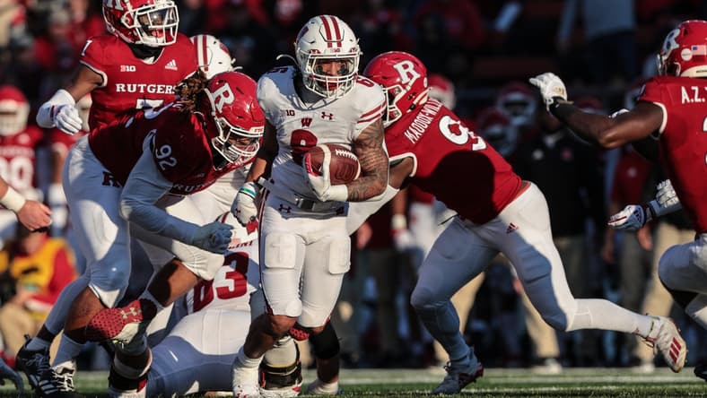 Nov 6, 2021; Piscataway, New Jersey, USA; Wisconsin Badgers running back Chez Mellusi (6) carries the ball as Rutgers Scarlet Knights defensive lineman Mayan Ahanotu (92) and linebacker Tyreek Maddox-Williams (9) pursue  during the first half at SHI Stadium. Mandatory Credit: Vincent Carchietta-USA TODAY Sports