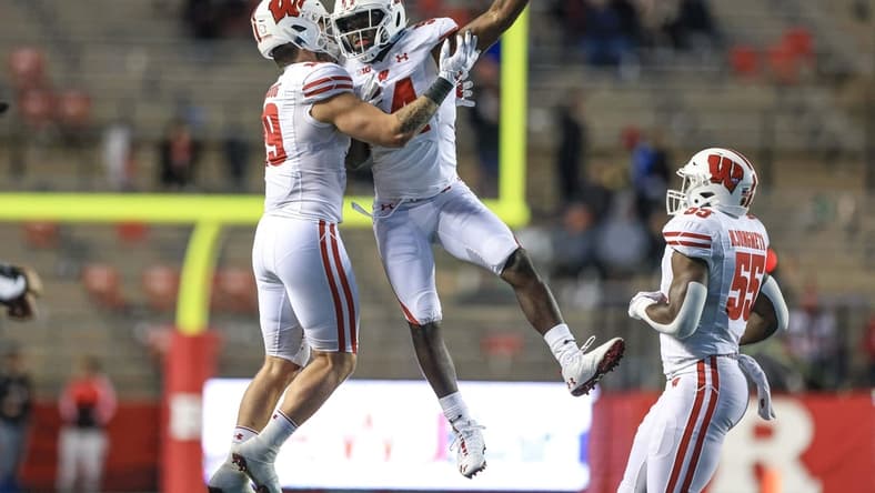 Nov 6, 2021; Piscataway, New Jersey, USA; Wisconsin Badgers linebacker Jordan Turner (54) celebrates his interception with linebacker Nick Herbig (19) and linebacker Maema Njongmeta (55) during the second half against the Rutgers Scarlet Knights at SHI Stadium. Mandatory Credit: Vincent Carchietta-USA TODAY Sports