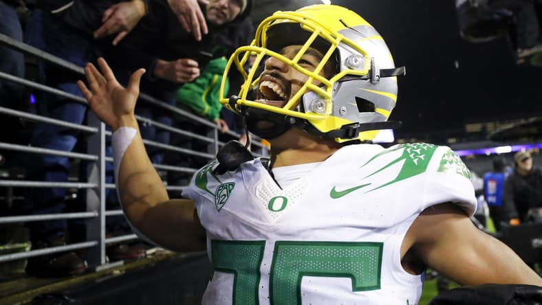Nov 6, 2021; Seattle, Washington, USA; Oregon Ducks running back Travis Dye (26) celebrates with fans following a 26-16 victory against the Washington Huskies at Alaska Airlines Field at Husky Stadium. Mandatory Credit: Joe Nicholson-USA TODAY Sports