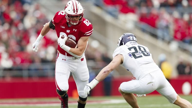 Nov 13, 2021; Madison, Wisconsin, USA; Wisconsin Badgers tight end Jack Eschenbach (82) rushes with the football as Northwestern Wildcats linebacker Chris Bergin (28) defends during the second quarter at Camp Randall Stadium. Mandatory Credit: Jeff Hanisch-USA TODAY Sports
