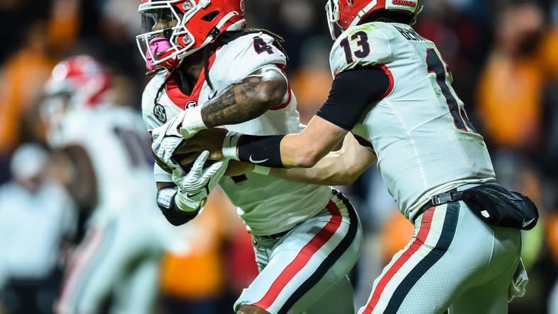 Nov 13, 2021; Knoxville, Tennessee, USA; Georgia Bulldogs running back James Cook (4) takes a hand off from quarterback Stetson Bennett (13) during the third quarter in a game against the Tennessee Volunteers at Neyland Stadium. Mandatory Credit: Bryan Lynn-USA TODAY Sports