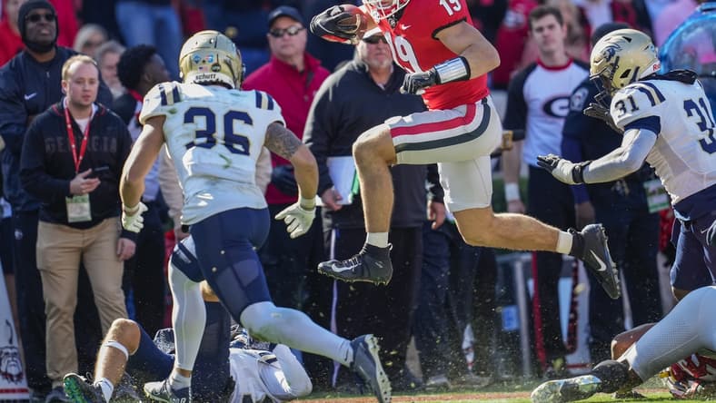 Nov 20, 2021; Athens, Georgia, USA; Georgia Bulldogs tight end Brock Bowers (19) jumps over Charleston Southern Buccaneers tacklers during the first quarter at Sanford Stadium. Mandatory Credit: Dale Zanine-USA TODAY Sports