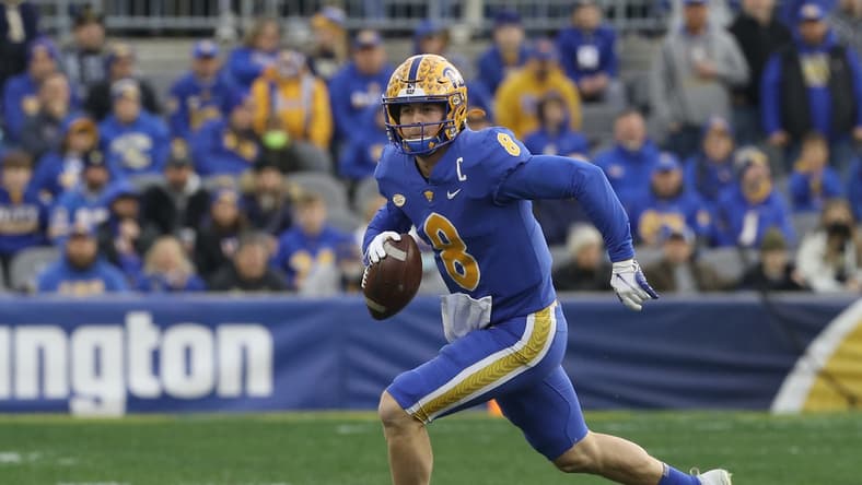 Nov 20, 2021; Pittsburgh, Pennsylvania, USA;  Pittsburgh Panthers quarterback Kenny Pickett (8) scrambles with the ball against the Virginia Cavaliers during the first quarter at Heinz Field. Mandatory Credit: Charles LeClaire-USA TODAY Sports