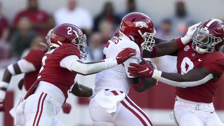Nov 20, 2021; Tuscaloosa, Alabama, USA; Arkansas running back Raheim Sanders (5) attempts to break a tackle by Alabama defensive back DeMarcco Hellams (2) and Alabama linebacker Christian Harris (8) at Bryant-Denny Stadium. Mandatory Credit: Gary Cosby Jr.-USA TODAY Sports