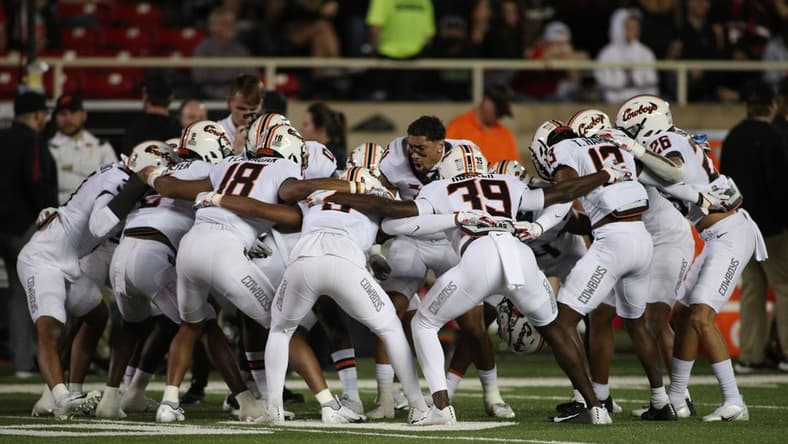 Nov 20, 2021; Lubbock, Texas, USA; The Oklahoma State Cowboys huddle before a game against the Texas Tech Red Raiders at Jones AT&T Stadium. Mandatory Credit: Michael C. Johnson-USA TODAY Sports