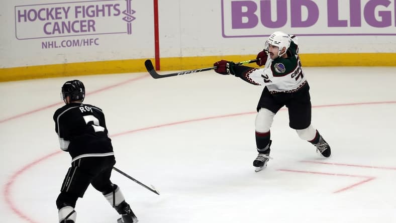 Nov 21, 2021; Los Angeles, California, USA; Arizona Coyotes defenseman Kyle Capobianco (75) shoots the game winning shot in the overtime against the Los Angeles King at Staples Center. The Coyotes wins 2-1. Mandatory Credit: Kiyoshi Mio-USA TODAY Sports