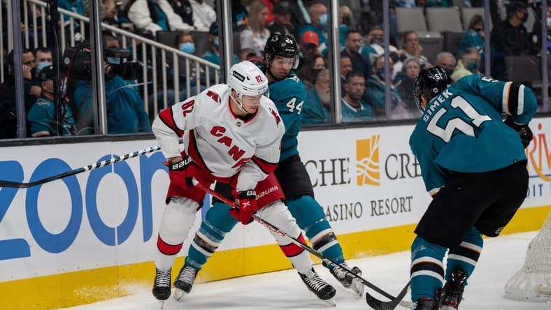 Nov 22, 2021; San Jose, California, USA; San Jose Sharks defenseman Marc-Edouard Vlasic (44) and defenseman Radim Simek (51) battle for the puck against Carolina Hurricanes center Jesperi Kotkaniemi (82) behind the net during the first period at SAP Center at San Jose. Mandatory Credit: Neville E. Guard-USA TODAY Sports