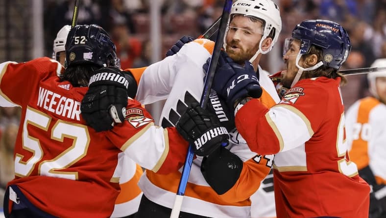 Nov 24, 2021; Sunrise, Florida, USA; Florida Panthers defenseman MacKenzie Weegar (52) pushes Philadelphia Flyers center Sean Couturier (14) during the first period at FLA Live Arena. Mandatory Credit: Sam Navarro-USA TODAY Sports