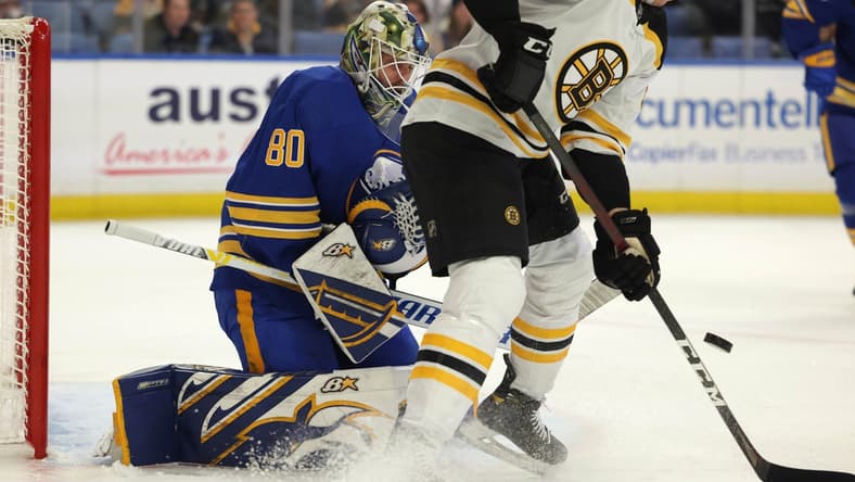 Nov 24, 2021; Buffalo, New York, USA; Boston Bruins left wing Tomas Nosek (92) tries to deflect a shot on Buffalo Sabres goaltender Aaron Dell (80) during the first period at KeyBank Center. Mandatory Credit: Timothy T. Ludwig-USA TODAY Sports