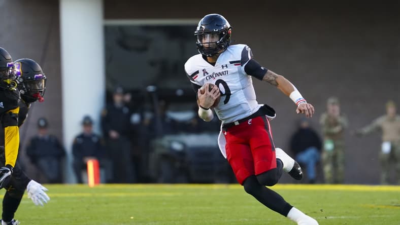 Nov 26, 2021; Greenville, North Carolina, USA;  Cincinnati Bearcats quarterback Desmond Ridder (9) runs with the ball during the first half against the East Carolina Pirates at Dowdy-Ficklen Stadium. Mandatory Credit: James Guillory-USA TODAY Sports