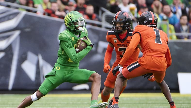 Nov 27, 2021; Eugene, Oregon, USA; Oregon Ducks wide receiver Devon Williams (2) catches a pass for a first down against Oregon State Beavers defensive back Jaydon Grant (3) and defensive back Rejzohn Wright (1) at Autzen Stadium. Mandatory Credit: Troy Wayrynen-USA TODAY Sports