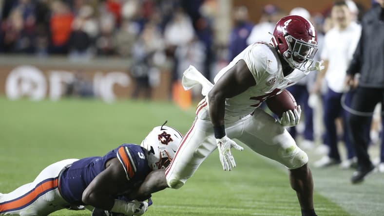 Nov 27, 2021; Auburn, Alabama, USA;  Auburn Tigers  linebacker Zakoby McClain (9) brings down Alabama Crimson Tide running back Brian Robinson Jr. (4) at Jordan-Hare Stadium. Alabama defeated Auburn in four overtimes. Mandatory Credit: Gary Cosby Jr.-USA TODAY Sports