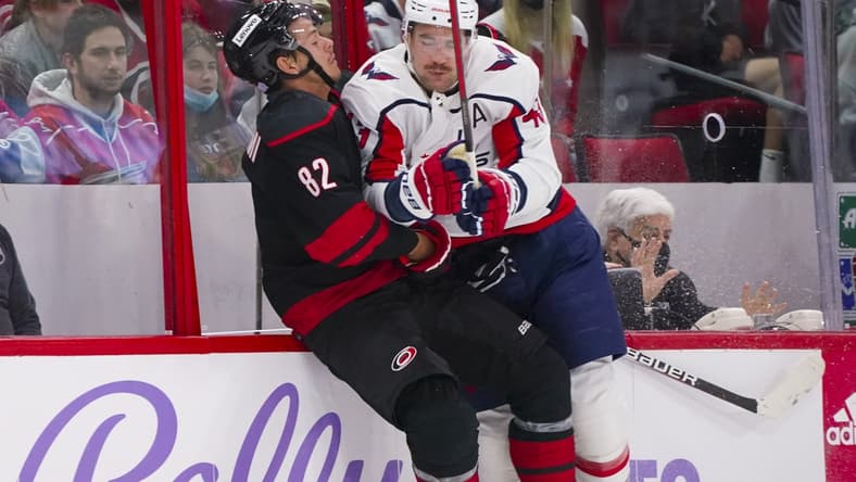 Nov 28, 2021; Raleigh, North Carolina, USA;  Washington Capitals right wing Tom Wilson (43) checks Carolina Hurricanes center Jesperi Kotkaniemi (82) during the first period at PNC Arena. Mandatory Credit: James Guillory-USA TODAY Sports