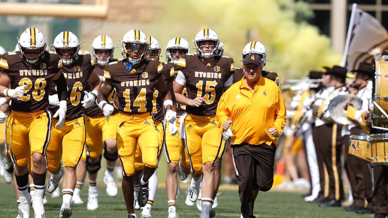 Sep 18, 2021; Laramie, Wyoming, USA; Wyoming Cowboys head coach Craig Bohl leads his team onto the field before game against the Ball State Cardinals at Jonah Field at War Memorial Stadium. Mandatory Credit: Troy Babbitt-USA TODAY Sports