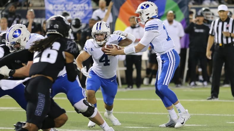 Oct 1, 2021; Logan, Utah, USA; Brigham Young Cougars quarterback Baylor Romney (16) hands the ball off to running back Lopini Katoa (4) during the first quarter against the Utah State Aggies at Merlin Olsen Field at Maverik Stadium. Mandatory Credit: Rob Gray-USA TODAY Sports
