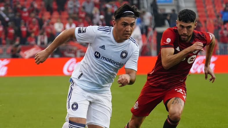Oct 3, 2021; Toronto, Ontario, CAN; Chicago Fire forward Ignacio Aliseda (7) gets by Toronto FC midfielder Jonathan Osorio (21) during the second half at BMO Field. Mandatory Credit: John E. Sokolowski-USA TODAY Sports
