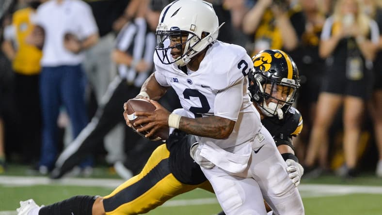 Oct 9, 2021; Iowa City, Iowa, USA; Penn State Nittany Lions quarterback Ta'Quan Roberson (2) eludes the tackle of Iowa Hawkeyes defensive back Dane Belton (4) during the fourth quarter at Kinnick Stadium. Mandatory Credit: Jeffrey Becker-USA TODAY Sports