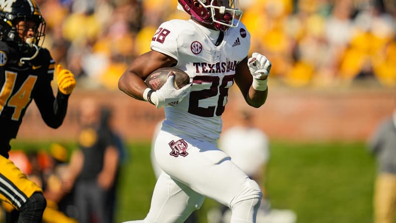 Oct 16, 2021; Columbia, Missouri, USA; Texas A&M Aggies running back Isaiah Spiller (28) runs for a touchdown against Missouri Tigers defensive back Kris Abrams-Draine (14) during the first half at Faurot Field at Memorial Stadium. Mandatory Credit: Jay Biggerstaff-USA TODAY Sports