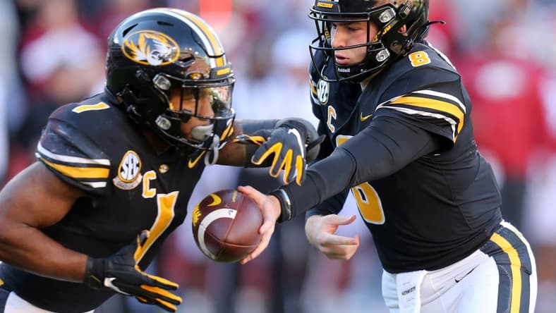 Nov 26, 2021; Fayetteville, Arkansas, USA; Missouri Tigers quarterback Connor Bazelak (8) hands the ball off to running back Tyler Badie (1) during the first quarter against the Arkansas Razorbacks at Donald W. Reynolds Razorbacks Stadium. Mandatory Credit: Nelson Chenault-USA TODAY Sports