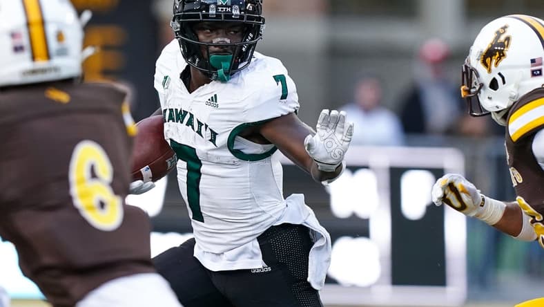 Nov 27, 2021; Laramie, Wyoming, USA; Hawaii Rainbow Warriors running back Calvin Turner Jr. (7) runs against the Wyoming Cowboys during the fourth quarter at Jonah Field at War Memorial Stadium. Mandatory Credit: Troy Babbitt-USA TODAY Sports