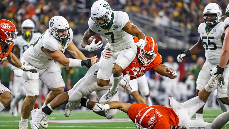 Dec 4, 2021; Arlington, TX, USA; Baylor Bears running back Abram Smith (7) hurdles Oklahoma State Cowboys defensive tackle Israel Antwine (95) during the first half of the Big 12 Conference championship game at AT&T Stadium. Mandatory Credit: Kevin Jairaj-USA TODAY Sports