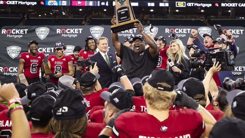 Dec 4, 2021; Detroit, MI, USA; Northern Illinois Huskies head coach Thomas Hammock holds up the trophy with his team after winning the MAC Championship Game against the Kent State Golden Flashes at Ford Field. Mandatory Credit: Raj Mehta-USA TODAY Sports