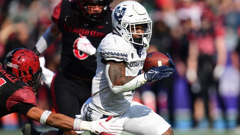 Dec 4, 2021; Carson, CA, USA; Utah State Aggies running back Calvin Tyler Jr. (4) runs the ball against San Diego State Aztecs safety C.J. Baskerville (34) during the first half of the Mountain West Conference championship game at Dignity Health Sports Park. Mandatory Credit: Gary A. Vasquez-USA TODAY Sports