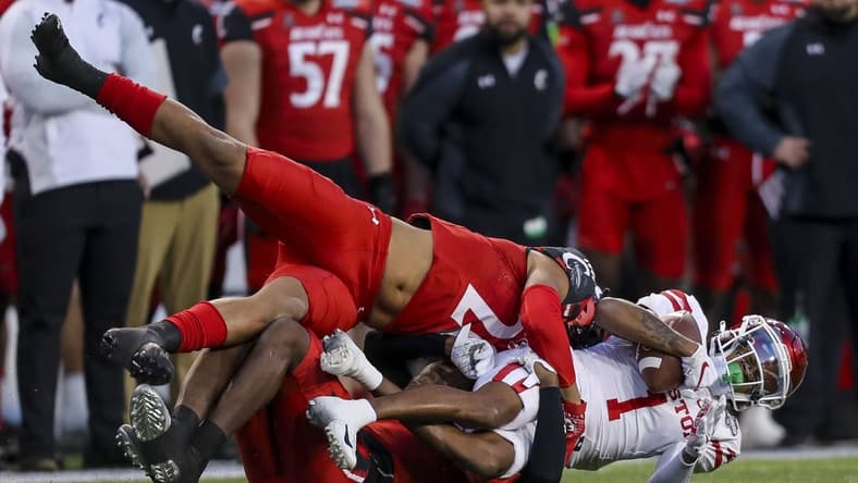 Dec 4, 2021; Cincinnati, Ohio, USA; Cincinnati Bearcats linebacker Deshawn Pace (20) and cornerback Arquon Bush (9) take down Houston Cougars wide receiver Nathaniel Dell (1) in the first half during the American Athletic Conference championship game at Nippert Stadium. Mandatory Credit: Katie Stratman-USA TODAY Sports