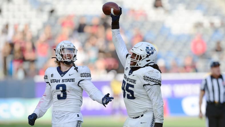 Dec 4, 2021; Carson, CA, USA; Utah State Aggies defensive tackle Marcus Moore (95) and linebacker Justin Rice (3) celebrate the fumble recovery against the San Diego State Aztecs during the second half of the Mountain West Conference championship game at Dignity Health Sports Park. Mandatory Credit: Gary A. Vasquez-USA TODAY Sports