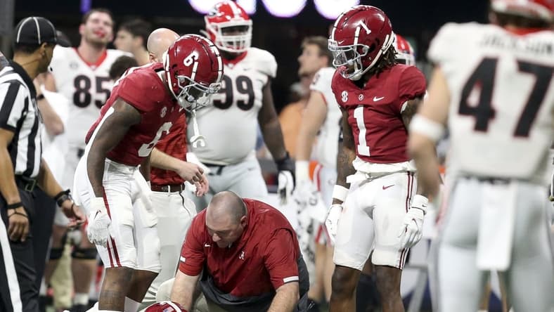 Dec 4, 2021; Atlanta, GA, USA; Trainers rush to the aide of Alabama wide receiver John Metchie III (8) after he was injured while playing against Georgia during the SEC championship game at Mercedes-Benz Stadium. Mandatory Credit: Gary Cosby Jr.-USA TODAY Sports