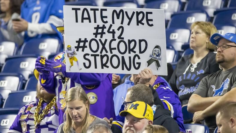 Dec 5, 2021; Detroit, Michigan, USA; A fans holds a sign for Tate Myre one of the Oxford High School shooting victims before the start of the NFL game between the Detroit Lions and the Minnesota Vikings at Ford Field. Mandatory Credit: David Reginek-USA TODAY Sports