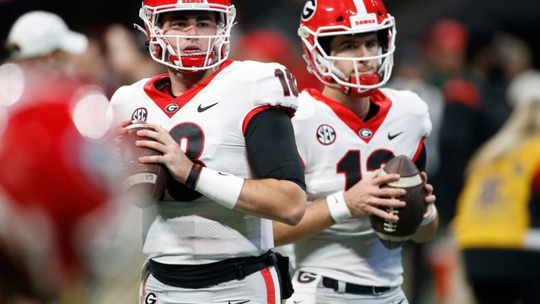 Georgia quarterback JT Daniels (18) and Georgia quarterback Stetson Bennett (13) warm up before the start the Southeastern Conference championship NCAA college football game between Georgia and Alabama in Atlanta, on Saturday, Dec. 4, 2021.

Syndication Online Athens