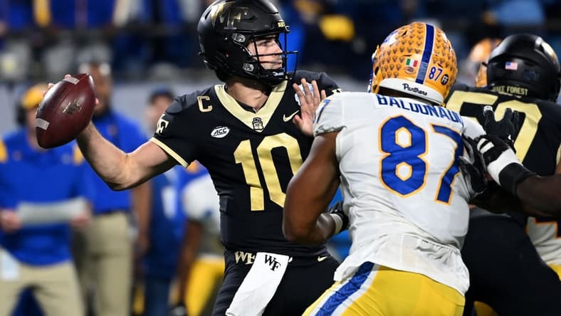 Dec 4, 2021; Charlotte, NC, USA; DWake Forest Demon Deacons quarterback Sam Hartman (10) looks to pass as Pittsburgh Panthers defensive lineman Habakkuk Baldonado (87) pressures in the second quarter of the ACC championship game at Bank of America Stadium. Mandatory Credit: Bob Donnan-USA TODAY Sports