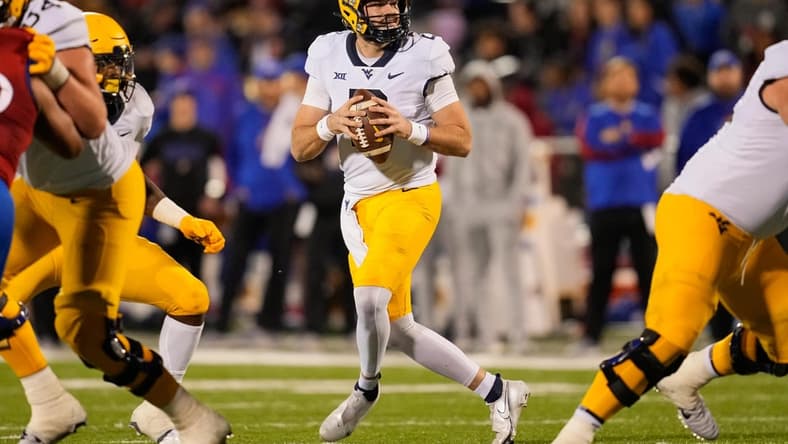 Nov 27, 2021; Lawrence, Kansas, USA; West Virginia Mountaineers quarterback Jarret Doege (2) drops back to pass against the Kansas Jayhawks during the first half at David Booth Kansas Memorial Stadium. Mandatory Credit: Jay Biggerstaff-USA TODAY Sports