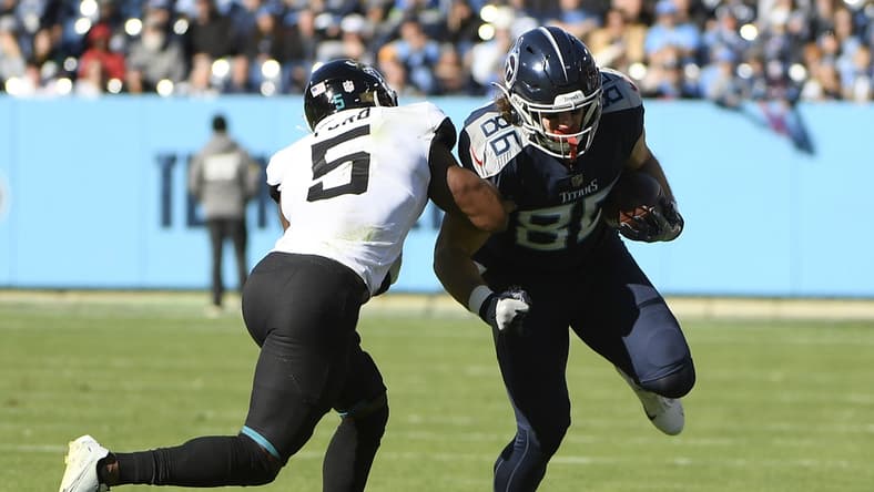 Dec 12, 2021; Nashville, Tennessee, USA; Tennessee Titans tight end Anthony Firkser (86) runs through the tackle of Jacksonville Jaguars defensive back Rudy Ford (5) during the first half at Nissan Stadium. Mandatory Credit: Steve Roberts-USA TODAY Sports