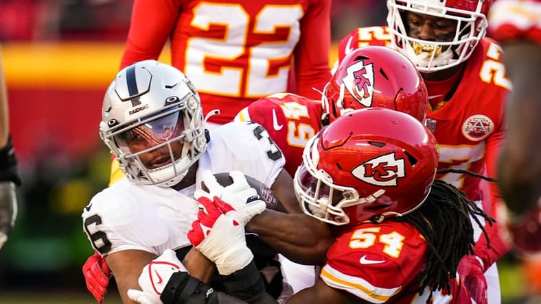 Dec 12, 2021; Kansas City, Missouri, USA; Las Vegas Raiders running back Trey Ragas (36) is tackled by Kansas City Chiefs defensive tackle Jarran Reed (90) and outside linebacker Nick Bolton (54) and safety Daniel Sorensen (49) during the second half at GEHA Field at Arrowhead Stadium. Mandatory Credit: Jay Biggerstaff-USA TODAY Sports