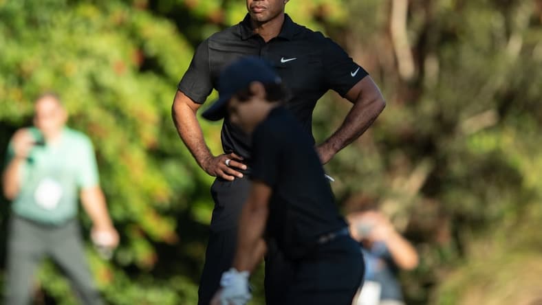 Dec 17, 2021; Orlando, Florida, USA; Tiger Woods watches son Charlie Woods play his shot from the first tee during a pro-am round of the PNC Championship golf tournament at Grande Lakes Orlando Course. Mandatory Credit: Jeremy Reper-USA TODAY Sports