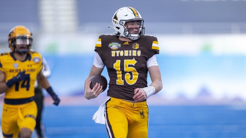 Dec 21, 2021; Boise, Idaho, USA; Wyoming Cowboys quarterback Levi Williams (15) runs the ball for a touchdown during the first half against the Kent State Golden Flashes during the 2021 Famous Idaho Potato Bowl at Albertsons Stadium. Mandatory Credit: Brian Losness-USA TODAY Sports
