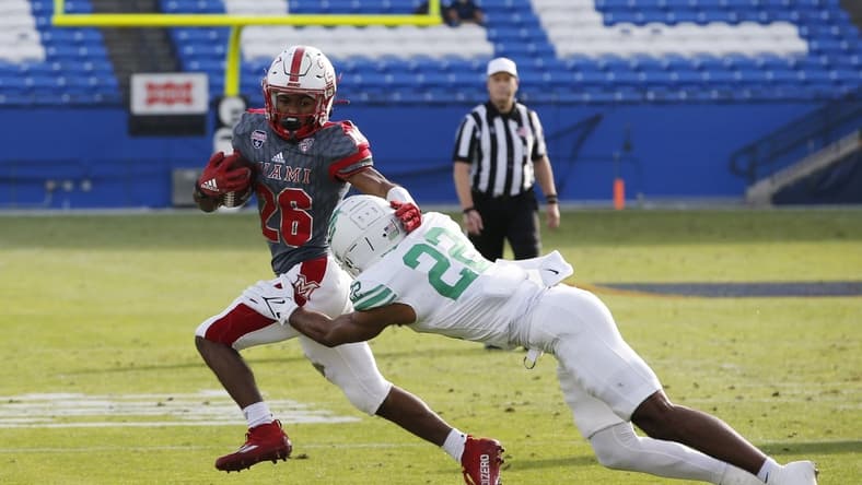 Dec 23, 2021; Frisco, TX, USA; Miami (Oh) Redhawks running back Kevin Davis (26) is tackled by North Texas Mean Green defensive back Keelan Crosby (22) in the first quarter at Toyota Stadium. Mandatory Credit: Tim Heitman-USA TODAY Sports