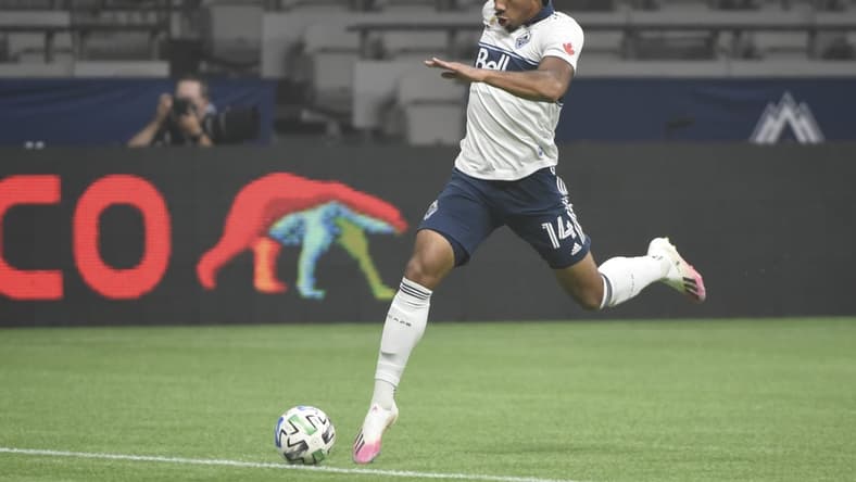 Sep 13, 2020; Vancouver, British Columbia, CAN; Vancouver Whitecaps midfielder Theo Bair (14) reaches for the ball against the Montreal Impact during the first half at BC Place. Mandatory Credit: Anne-Marie Sorvin-USA TODAY Sports