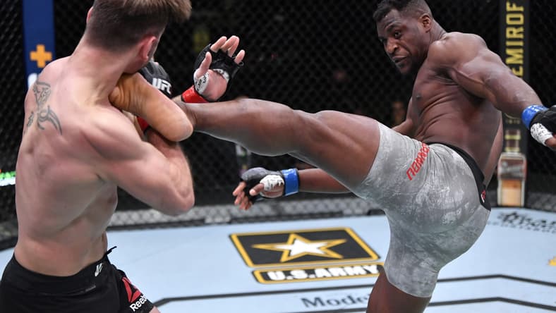 Mar 27, 2021; Las Vegas, NV, USA; Francis Ngannou of Cameroon kicks Stipe Miocic in their UFC heavyweight championship fight during the UFC 260 event at UFC APEX on March 27, 2021 in Las Vegas, Nevada.   Mandatory Credit: Jeff Bottari/Handout Photo via USA TODAY Sports
