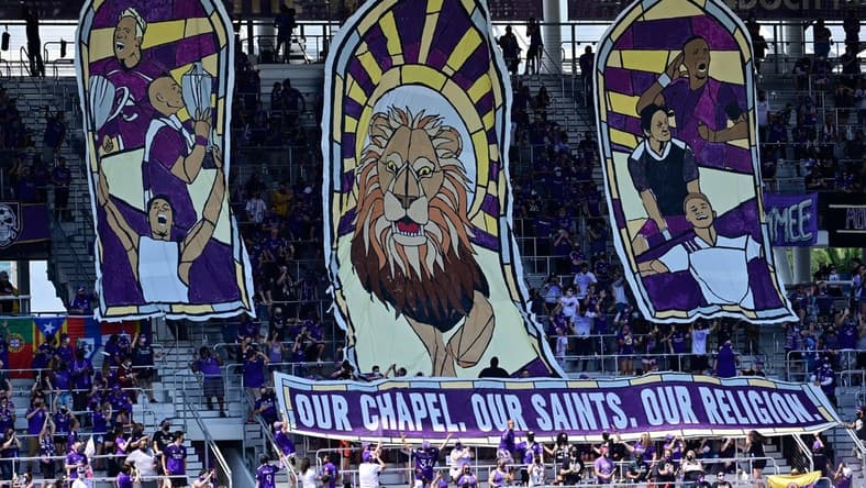 Apr 17, 2021; Orlando, Florida, USA; General view of the Orlando City SC supporters stands raising a sign prior to the game against the Atlanta United FC at Orlando City Stadium. Mandatory Credit: Douglas DeFelice-USA TODAY Sports