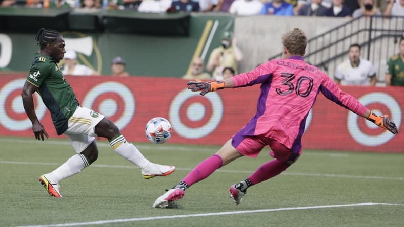 Aug 15, 2021; Portland, Oregon, USA; Seattle Sounders FC goalkeeper Stefan Cleveland (30) stretches to stop the ball kicked by Portland Timbers midfielder Yimmi Chara (23) during the first half at Providence Park. Mandatory Credit: Soobum Im-USA TODAY Sports