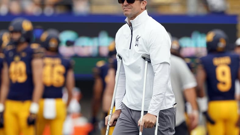 Sep 18, 2021; Berkeley, California, USA; California Golden Bears head coach Justin Wilcox stands on the field with crutches before the game against the Sacramento State Hornets at FTX Field at California Memorial Stadium. Mandatory Credit: Darren Yamashita-USA TODAY Sports
