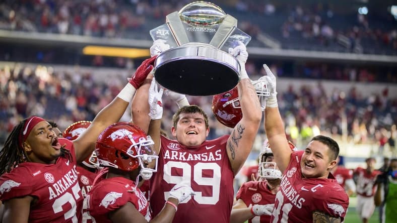 Sep 25, 2021; Arlington, Texas, USA; Arkansas Razorbacks defensive lineman Eric Thomas Jr. (37) and defensive lineman John Ridgeway (99) and linebacker Grant Morgan (31) hold up the Southwest Classic trophy as they celebrate the win over the Texas A&M Aggies at AT&T Stadium. Mandatory Credit: Jerome Miron-USA TODAY Sports