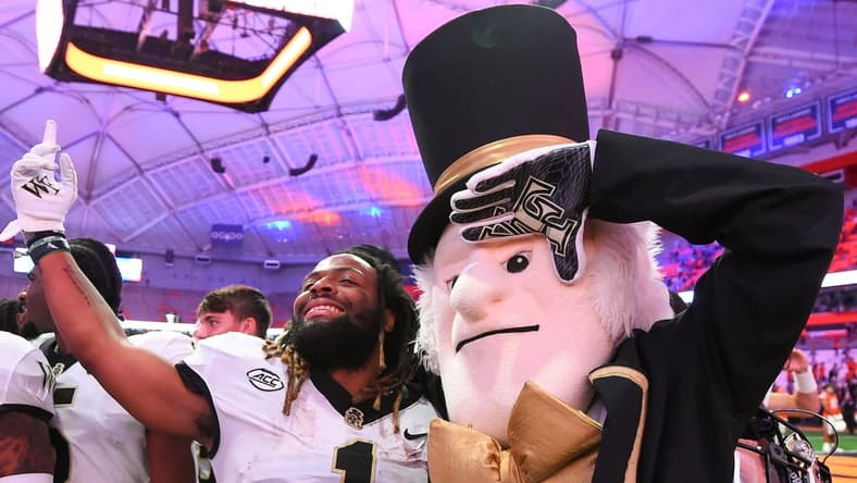 Oct 9, 2021; Syracuse, New York, USA; Wake Forest Demon Deacons running back Christian Beal-Smith (1) poses for a photo with mascot Demon Deacon following the game against the Syracuse Orange at the Carrier Dome. Mandatory Credit: Rich Barnes-USA TODAY Sports