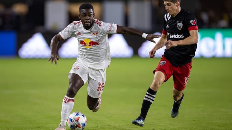 Oct 27, 2021; Washington, District of Columbia, USA; New York Red Bulls midfielder Dru Yearwood (16) dribbles the ball as D.C. United defender Frederic Brillant (13) defends during the second half at Audi Field. Mandatory Credit: Scott Taetsch-USA TODAY Sports